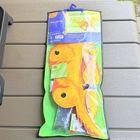 Front view of packaged wind spinner showing dog fabric parts and hardware bag