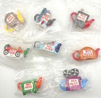 All eight sealed miniature teapots in bags, overhead view
