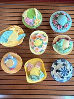 All nine ceramic hat trinket boxes arranged on wood surface