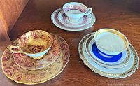 Overall view of three stacked tea trios showing patterns and colour schemes