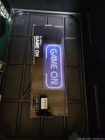 Front of retail box showing GAME ON neon sign image