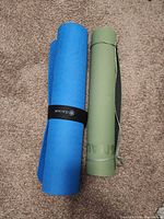 Blue and green rolled yoga mats side by side