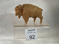 left side profile of carved wooden bison