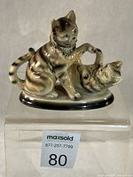 Front view of porcelain two-cat figurine on stand