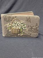 Front cover showing embossed floral basket and butterfly design