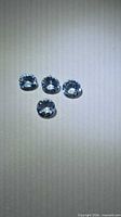 Top view of four pale blue round aquamarines
