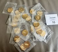 All 25 sealed coins spread out showing both sides through pouches