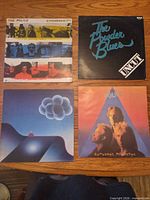 Front jackets of all four LPs arranged on tabletop