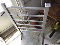Front view of silver freestanding heated towel rack with power cord