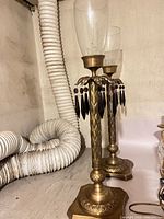 Full view of both brass candlesticks with prisms and glass chimneys