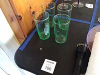 Four green ribbed tumblers on table
