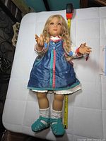 Full view of 24-inch Annette Himstedt doll with tape measure for scale