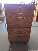 Front view showing two drawers, label holders, lock and casters