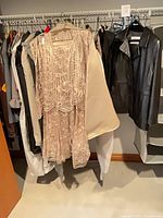 Closet rod with beige lace dress set, garment bags, black faux leather jacket