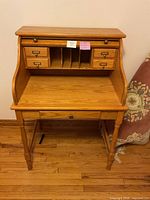 Front view showing full desk, upper drawers, cubbies, lower drawer, legs