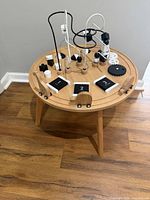 Full view of round wooden activity table and attached play elements
