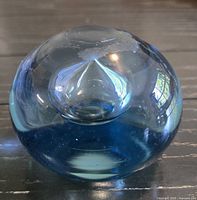 blue spherical glass paperweight with internal bubble