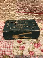 Top view of torn green Burman clipper box