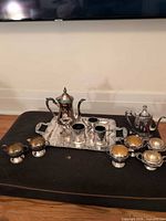 Full set arranged on ottoman showing tray, pots, cups and bowls