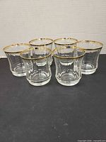 Front view of all six gold-rimmed tumblers