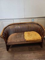 Front view of curved wooden couch showing overall form and seat condition