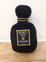 Front view showing "Koko Noir Chewnel France" label on black plush bottle