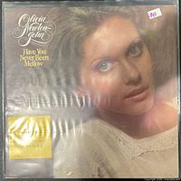 Front cover of Have You Never Been Mellow LP in plastic sleeve showing artist name and album title