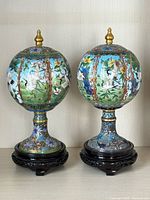 Pair of cloisonné pedestal globe vases with lids on wood stands