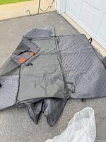 Quilted black back seat cover laid out, showing overall construction