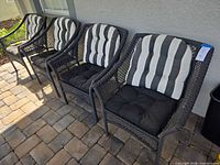 Four resin wicker patio chairs with cushions placed side by side