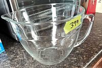Side view of clear glass 4-cup measuring bowl showing handle, spout and embossed graduations