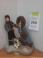 Front view of mixed-material angel figurine group showing all characters and base