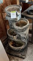 Full view of resin three-tier outdoor fountain showing antiqued gray finish and overall condition