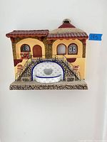 Front view of glazed ceramic wall plaque showing entire hacienda scene and color details