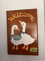 Front view of the wooden welcome plaque with geese motif