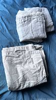 Two folded stacks: linen panel with Pottery Barn tag, gauze panel stack