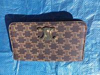 Front view of the Celine wallet showing monogram canvas and gold-tone Triomphe logo hardware