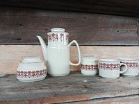 Entire set: lidded sugar bowl, coffee pot with lid, creamer, two of the mugs visible