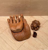 Large and medium hand carvings with small hand and figure