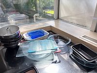Overall view showing stacked round pans, loaf pans, cutting boards, glass and ceramic casseroles