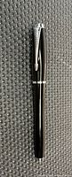 Full view of closed pen on textured surface