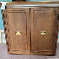 Front view showing two raised panel doors and brass recessed pulls