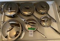 Overview of five Lagostina stainless pots and pans with lids