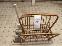 Rattan magazine rack alongside toilet brush and coasters