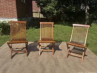 Front view of all three matching teak folding chairs