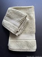 Stack of sage textured towels showing two hand towels and four wash cloths