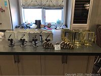 Photo showing 4 table number stands labeled 1 to 4 with black pedestal bases, 6 gold menu stands arranged beside them, and a gold 'Mr and Mrs' sign in front.