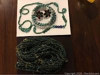 Green beaded bracelet, turquoise beaded necklace with antique clip-on floral earrings, and multi-strand green and black beaded necklace/belt.