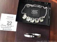 Joan Rivers necklace and bracelet set displayed on dark surface inside black box with jewelry card
