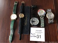 Five watches laid out showing dials and straps